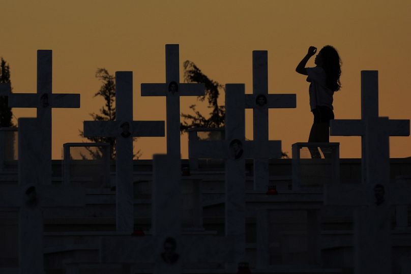 FILE - a girl walks by the graves of soldiers killed in the1974 Turkish invasion of Cyprus in the Tymvos Macedonitissas military cemetery in Nicosia - 2023.