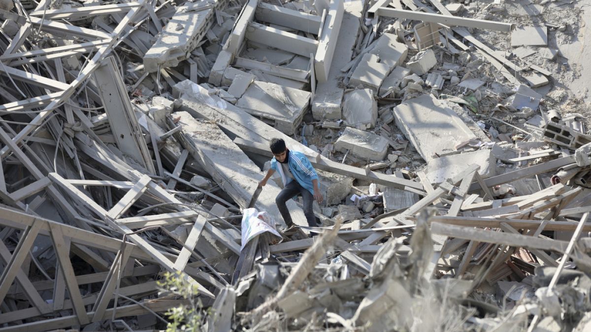 Palestinians walk through the destruction left by the Israeli air and ground offensive on the Gaza Strip in Gaza City, Saturday, Feb. 10, 2024. 
