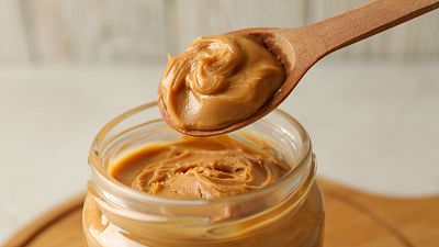 Spoon and jar with peanut butter