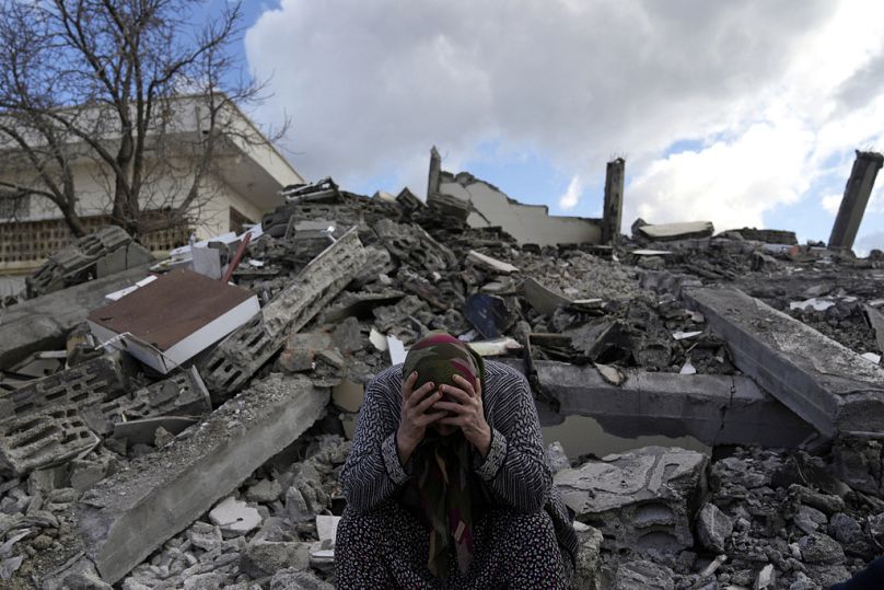 Eine Frau sitzt auf den Trümmern eines zerstörten Gebäudes der türkischen Stadt Nurdag, 7. Februar 2023