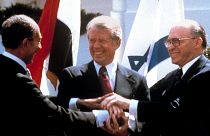 رئیس جمهور مصر انور سادات، سمت چپ، رئیس جمهور ایالات متحده، جیمی کارتر، وسط و مناخیم بگین، نخست وزیر اسرائیل، در حالی امضای معاهده صلح بین مصر و اسرائیل، واشنگتن ۱۹۷۹