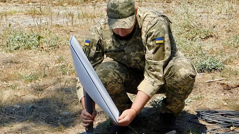 Ukrán katona Starlink egységet helyez üzembe