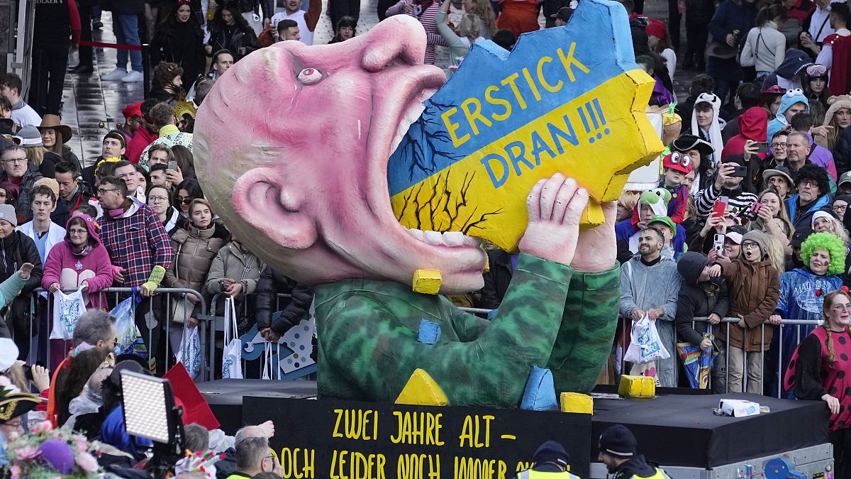 "Подавись!" - президент России Владимир Путин, пожирающий Украину, на карнавальном параде в Дюссельдорфе, 12 февраля 2024 г.