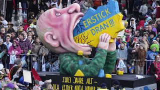 "Подавись!" - президент России Владимир Путин, пожирающий Украину, на карнавальном параде в Дюссельдорфе, 12 февраля 2024 г.