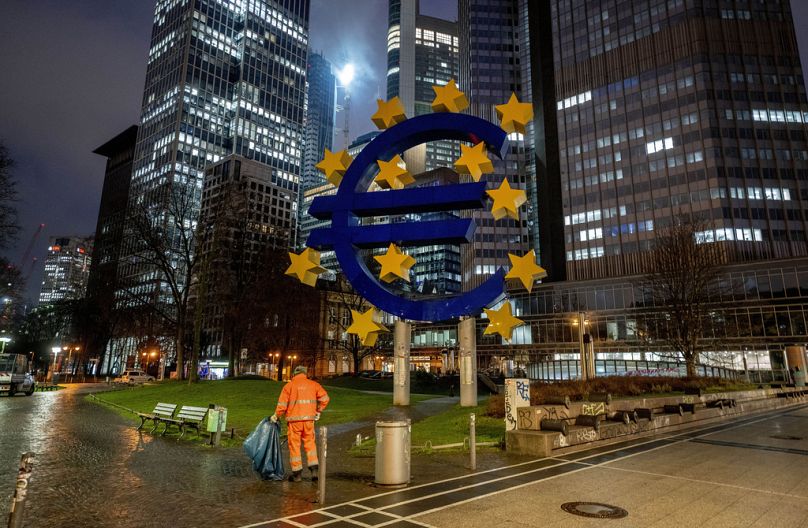 A public worker cleans the area around the former headquarters of the European Central Bank in Frankfurt, January 2024