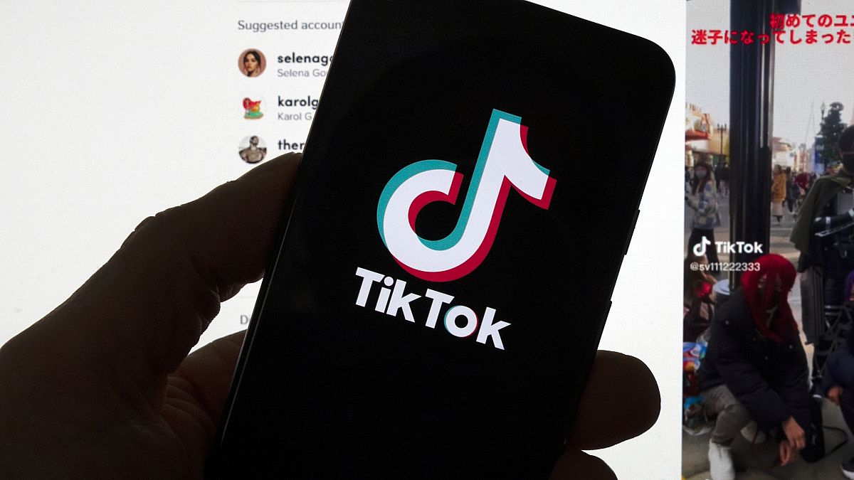 Il logo di TikTok è visibile su un telefono cellulare davanti allo schermo di un computer che visualizza la schermata iniziale di TikTok, sabato 18 marzo 2023, a Boston.