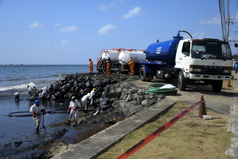 Workers from state own Heritage Petroleum Oil and Gas Company clean up an oil spill in south western Tobago.