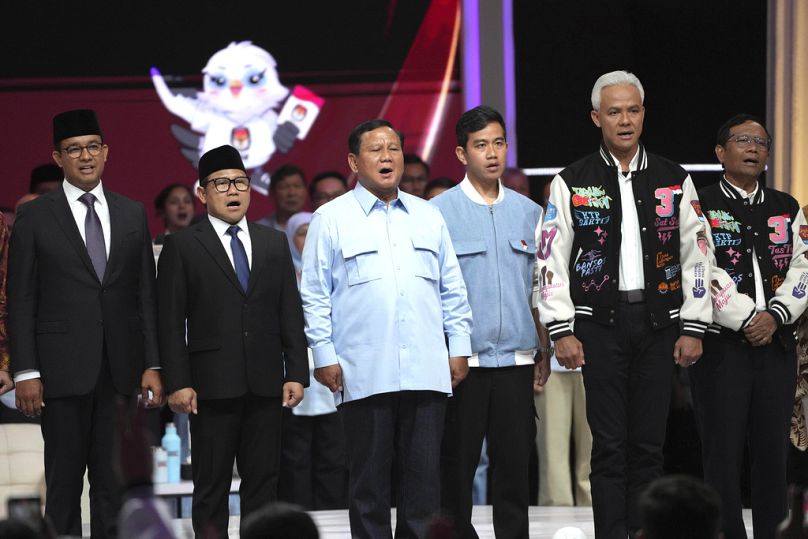 Presidential candidates stand on the stage as they sing a national song "For You My Country" after a televised presidential candidates' debate in Jakarta, February 2024