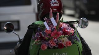 An Uber worker carries a bouquet of flowers to be delivered (file photo)