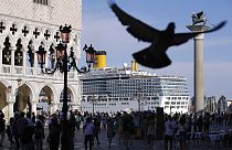 Sur cette photo d'archive, un bateau de croisière passe devant la place Saint-Marc remplie de touristes, à Venise, en Italie.