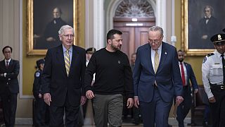 El presidente ucraniano Volodímir Zelenski, en el centro, es escoltado por Mitch McConnell, a la izquierda, y Chuck Schumer, mientras llega al Capitolio, en Washington.