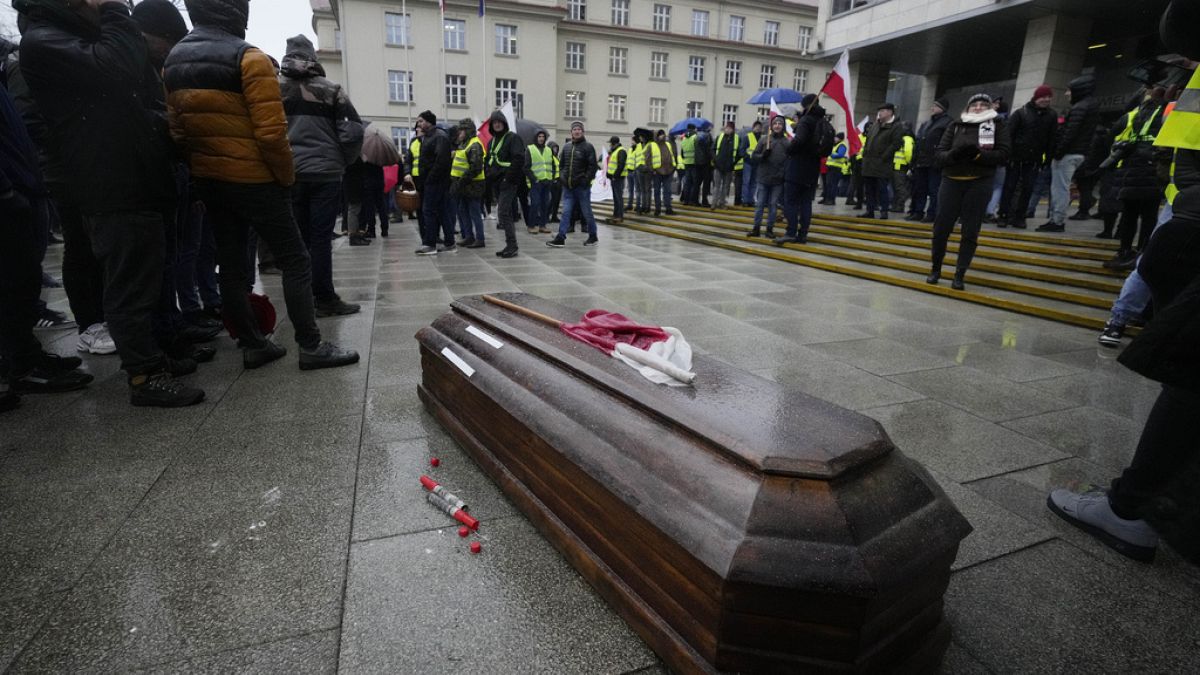 Polnische Bauern symbolisieren den Tod der polnischen Agrarindustrie anhand eines Sarges.