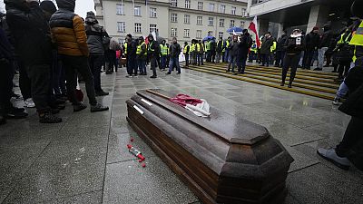 Polnische Bauern symbolisieren den Tod der polnischen Agrarindustrie anhand eines Sarges.
