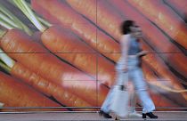 Shoppers walk past a large poster outside a supermarket in London, on June 10, 2023.