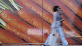 Shoppers walk past a large poster outside a supermarket in London, on June 10, 2023.