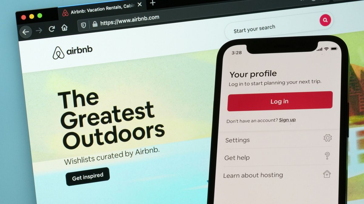 Η σελίδα σύνδεσης για την εφαρμογή iPhone της Airbnb φαίνεται μπροστά από έναν υπολογιστή που εμφανίζει τον ιστότοπο της Airbnb στις 8 Μαΐου 2021 στην Ουάσιγκτον. 