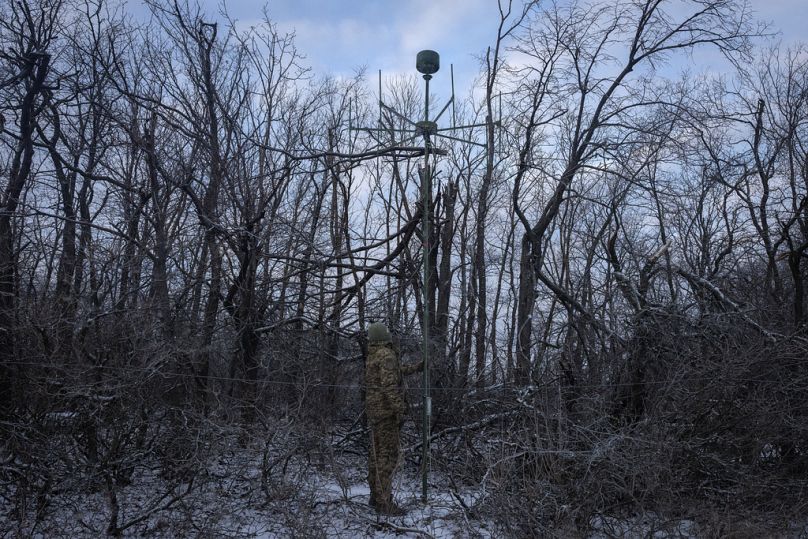 Un soldato ucraino installa un'antenna per intercettare i segnali radio russi