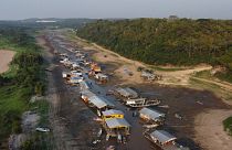 Case e barche galleggianti giacciono bloccate sul letto asciutto del lago Puraquequara, in un periodo di grave siccità a Manaus, nello Stato di Amazonas, in Brasile, nell'ottobre 2023.