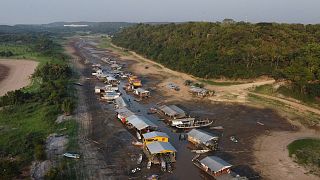 Case e barche galleggianti giacciono bloccate sul letto asciutto del lago Puraquequara, in un periodo di grave siccità a Manaus, nello Stato di Amazonas, in Brasile, nell'ottobre 2023.
