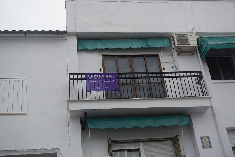 An 'Agua ya', meaning 'water already' banner hangs from a balcony in Pozoblanco.