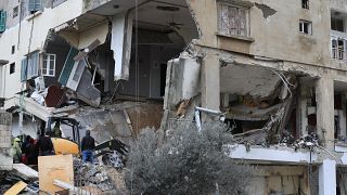 La défense civile et des secouristes enlèvent les décombres d'un bâtiment frappé mercredi soir par une frappe israélienne à Nabatiyé, au Liban, jeudi 15 février.
