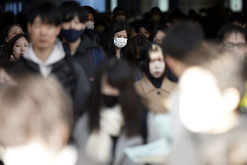 Japonya'da yolcular, 14 Şubat 2024 çarşamba günü Shinagawa İstasyonu'ndaki bir geçitte yürüyor