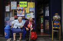 Two elderly women enjoy the day while they rest outside a shop, in Pamplona, northern Spain on Monday, June 17, 2013.