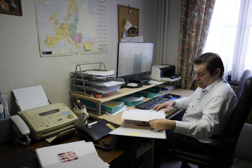 Bart Dochy looks through accounting books and logs entries on his computer at his family farm in Ledegem, Belgium.