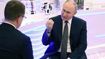 Le président russe Vladimir Poutine fait un geste lors de son entretien avec le correspondant de la télévision d'État russe Rossiya 1, Pavel Zarubin, à Moscou.