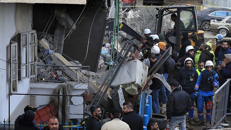 Civil defense and rescue workers remove rubbles from a building that was attacked Wednesday night by an Israeli airstrike, in Nabatiyeh town, south Lebanon, Thursday, Feb. 15,