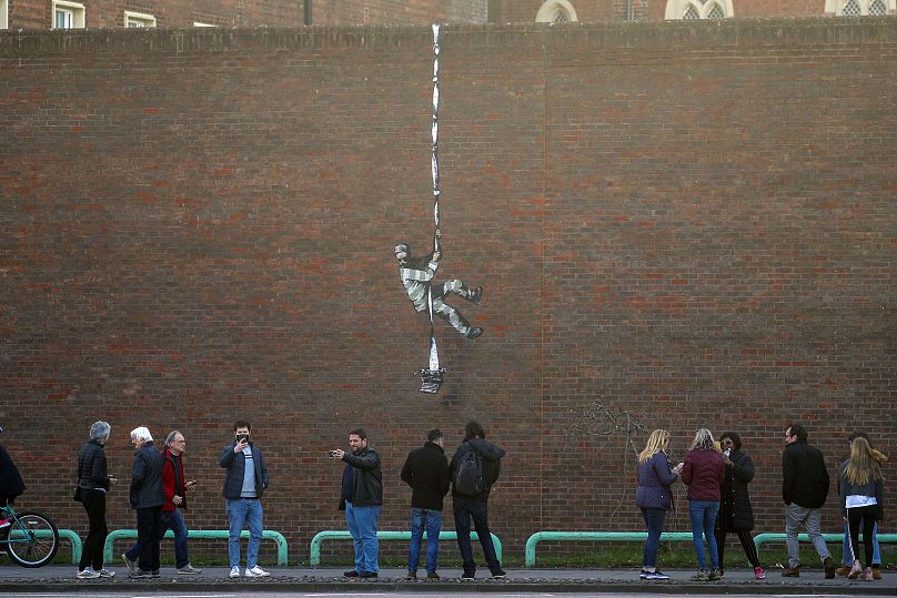 Street artist Banksy confirmed that he was behind the artwork that appeared on the red brick wall of a former prison in the English town of Reading.