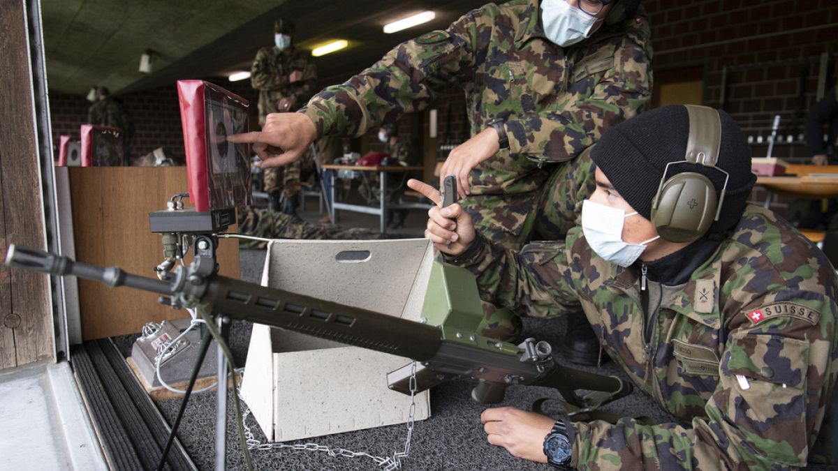 Soldiers of the Swiss army wear protective face masks during a rifle shooting exercise in the military compound of Chamblon near Yverdon-les-Bains, Switzerland, on April 2020.