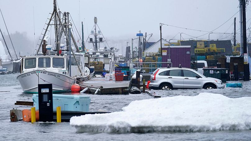 A car sits in a flooded parking lot at Widgery Wharf, 10 January 2024, in Portland, Maine.