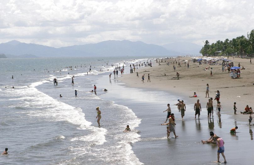 Tourists play in the surf in the Pacific port of Puntarenas, Costa Rica, October 2006