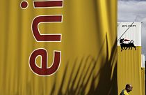 An employee walks by banners with name and sign of energy firm Eni at Strovolos area in capital Nicosia, Cyprus, on Friday, Feb. 23, 2018.