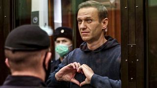 أليكسي نافالني يعمل إشارة "قلب" أثناء تواجده في قفص الاتهام في محكمة بالعاصمة الروسية موسكو