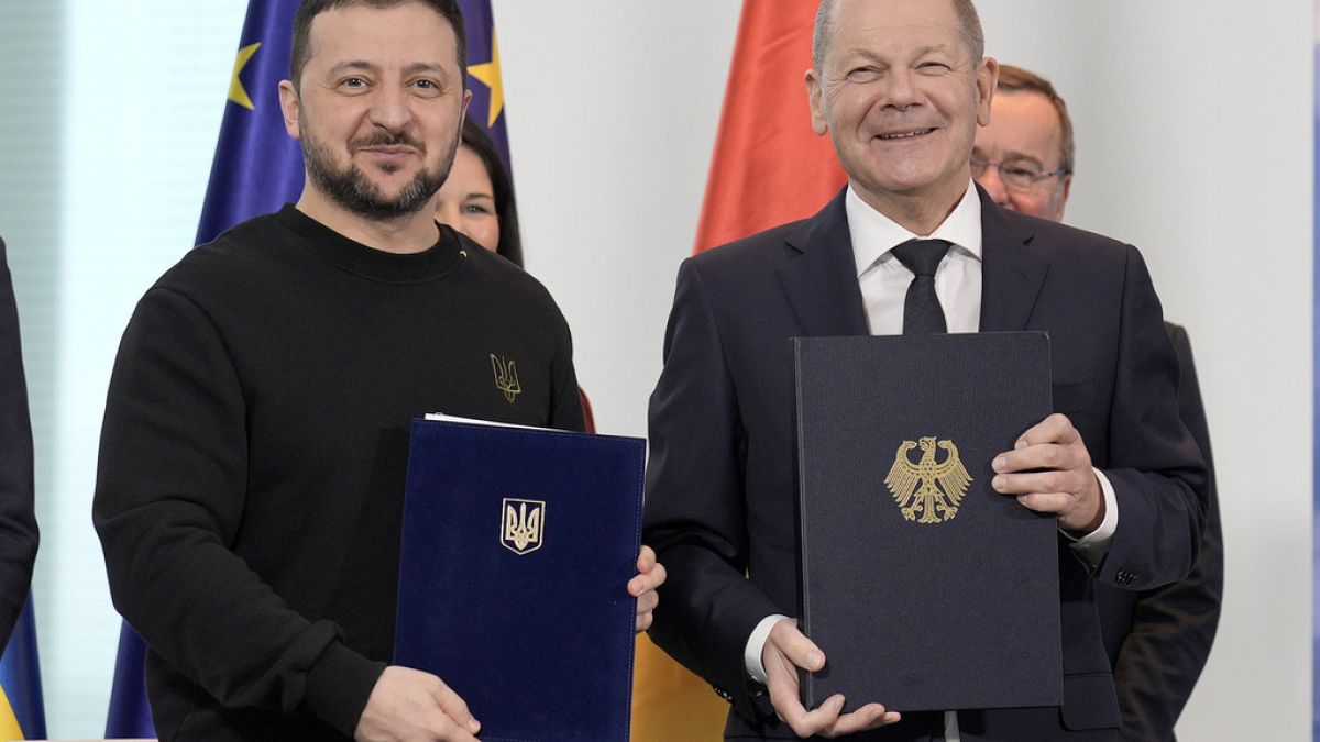 El canciller alemán Olaf Scholz, a la derecha, y el presidente ucraniano Volodímir Zelenski muestran los tratados firmados en Berlín, Alemania, el viernes 16 de febrero