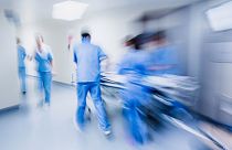 Doctors and nurses pulling hospital trolley