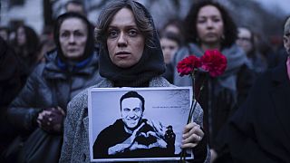 Eine Frau mit Blumen und einem Porträt des Kremlkritikers Alexei Nawalny während einer Protestaktion vor der russischen Botschaft in Berlin, 16. Februar 2024