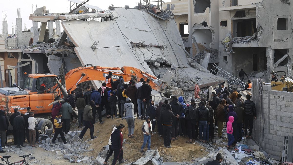 Des Palestiniens observent les dégâts causés par une frappe israélienne sur un immeuble résidentiel à Rafah, dans la bande de Gaza, le 16 février 2024. 