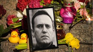 Ein Porträt des russischen Oppositionsführers Alexej Nawalny, Blumen und Kerzen an der Gedenkstätte für die Opfer politischer Repression in St. Petersburg, 16. Februar 2024