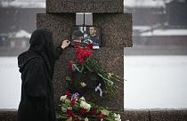 Una donna lascia un fiore per commemorare Alexei Navalny