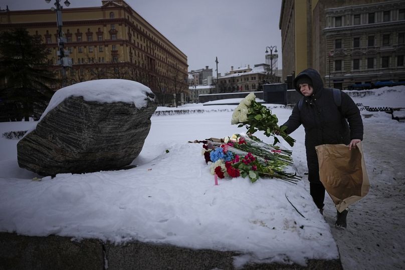 Moskova'da FSB binasının önündeki bir anıta Alexey Navalny'yi anmak için çiçek bırakan bir kadın