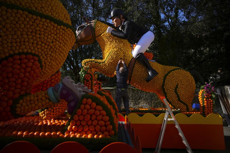 A worker places lemons on an olympic equestrian carnival float during the 90th Olympia in Menton edition of the Lemon Festival in Menton, southern France, 17 Feb 2024.