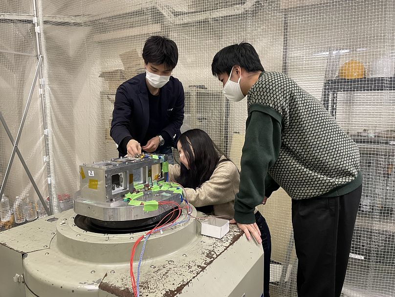 Bir öğrenci ekibi Kyushu Teknoloji Enstitüsü Nano-Uydu Test Merkezi'ndeki titreşim test cihazında LignoSat 1'in titreşim testine hazırlanıyor