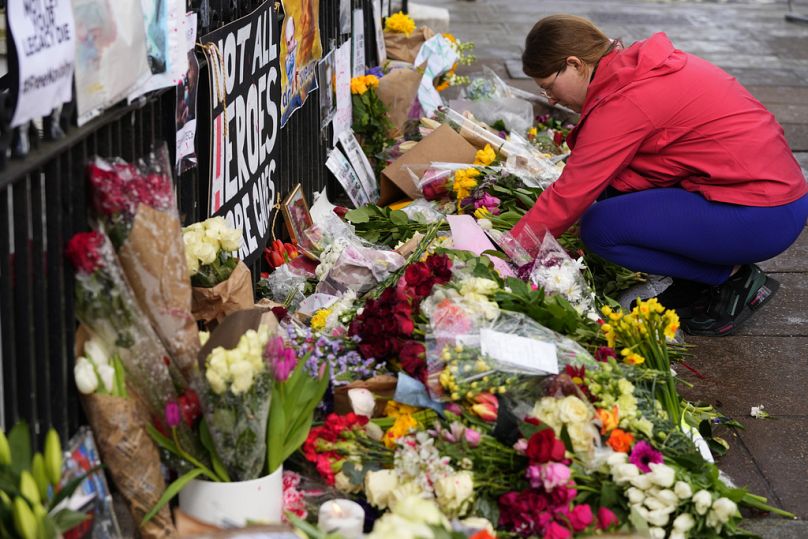 A woman leaves a tribute to Russian politician Alexi Navalny, near to the Russian Embassy in London, Sunday, Feb. 18, 2024.