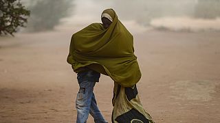 Somalili mülteci çocuklar, 13 Temmuz 2023 Perşembe günü, Kenya'nın kuzeyindeki Dadaab mülteci kampında toz fırtınası yaşanırken üzerlerini örtüyor.