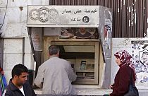 İsrail işgali altındaki Batı Şeria'nın Ramallah kentinde bir ATM'den maaş çeken Filistinliler (arşiv) 