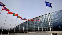 Flags of NATO alliance members flap in the wind outside NATO headquarters in Brussels, on Feb. 28, 2020.
