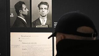 A visitor watches the Nov.18, 1943 police mugshot of Missak Manouchian, exhibited at the Shoah memorial, Tuesday, Feb. 20, 2024 in Paris.